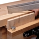 Hand sägt Holz auf einem stabilen Holzgerüst, geeignet für Bau- und Renovierungsarbeiten.