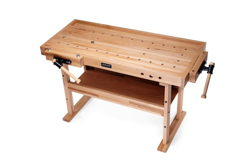 Robuster Arbeitstisch aus Holz mit Schraubzwingen für präzises Arbeiten auf dem Rollgerüst.